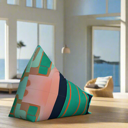 Rear of colourful pink green and navy bean bag shown, sits in a light filled beach house